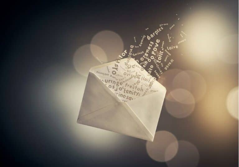 A imagem mostra um envelope aberto, de onde emergem palavras flutuantes, formando uma espécie de fluxo etéreo que se dissolve no ar. As palavras são representadas em diferentes tamanhos e orientações, criando um efeito dinâmico e artístico. O fundo desfocado e iluminado por luzes suaves transmite uma atmosfera onírica e poética, evocando a ideia de comunicação, mensagens e pensamentos ganhando vida.